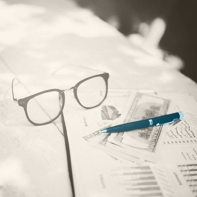 calculator, glasses and laptop on a desk