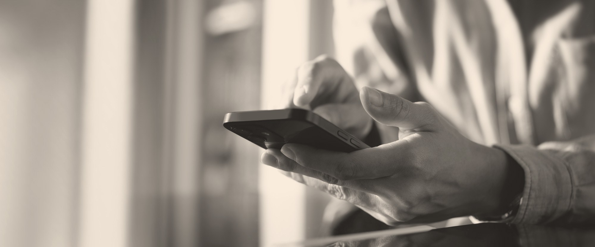 hand holding a mobile phone with the PAHOwho FCU homepage on it